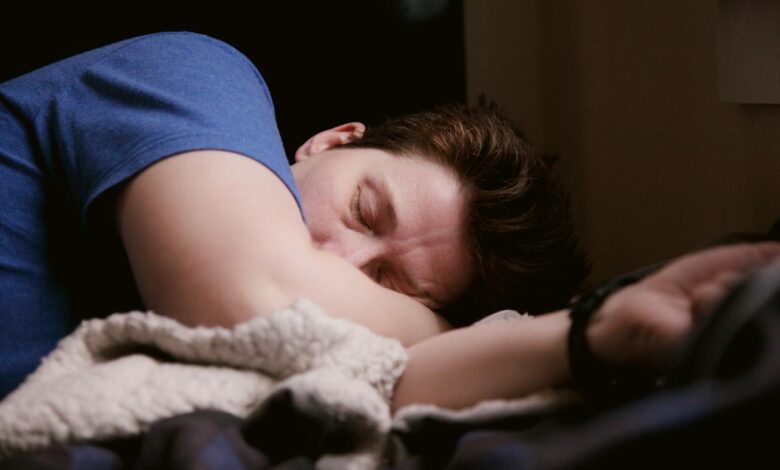 woman in blue shirt lying on bed