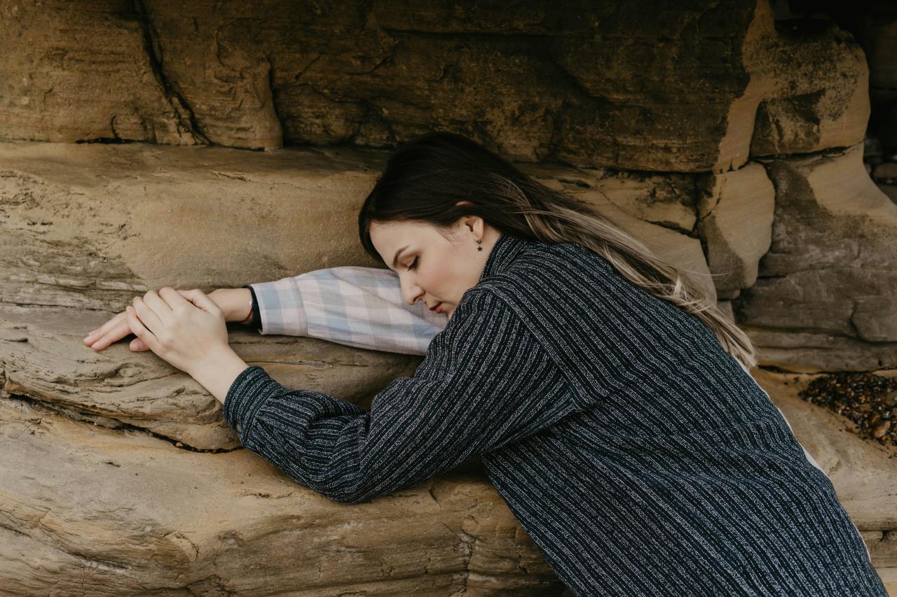woman in black and white striped long sleeve shirt lying on brown sand